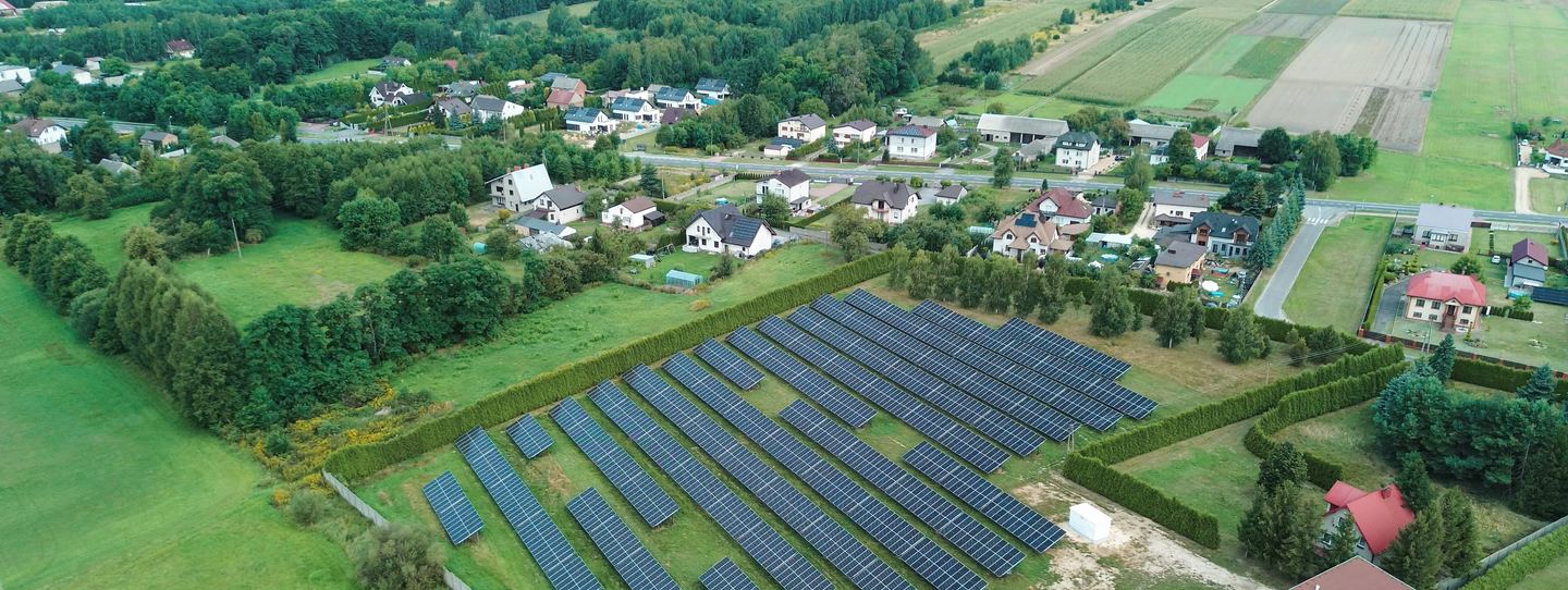 Aerial view of solar arrays in a rural landscape.