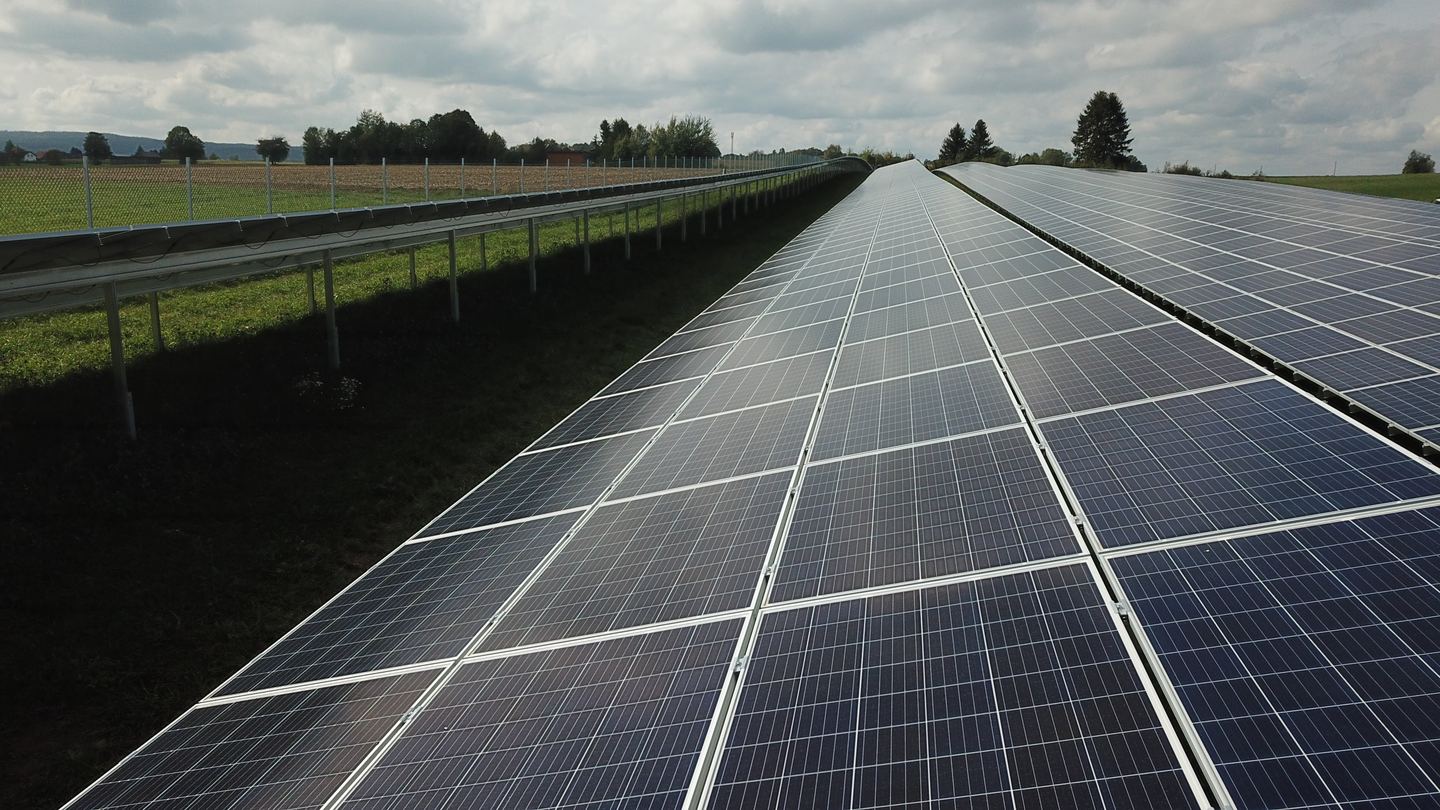 Close-up of solar panels in a field that extend straight into the distance.